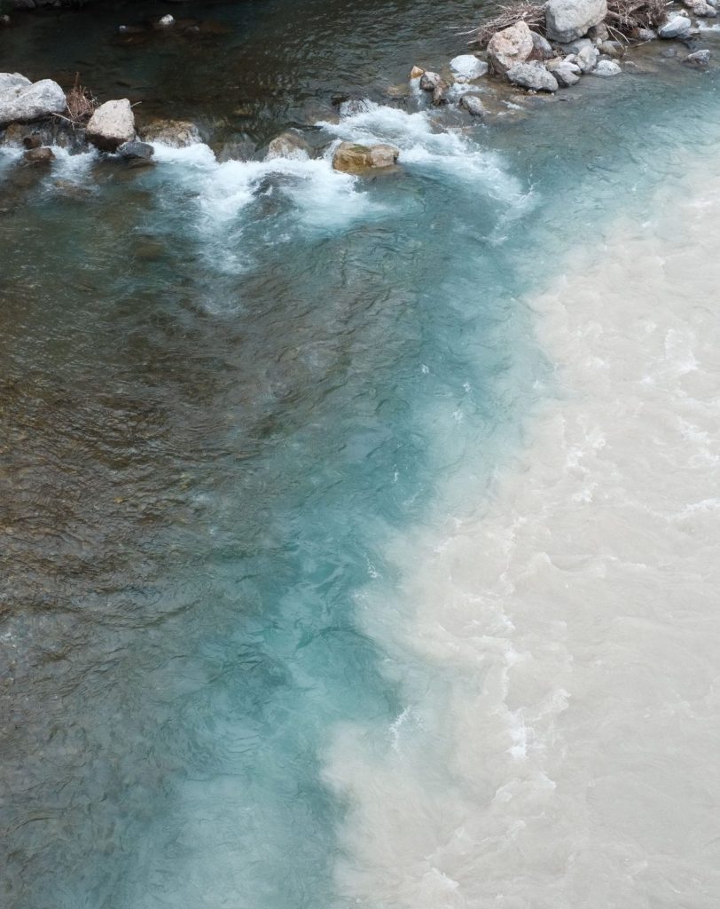 Confluence de deux rivières, l’une claire et l’autre laiteuse